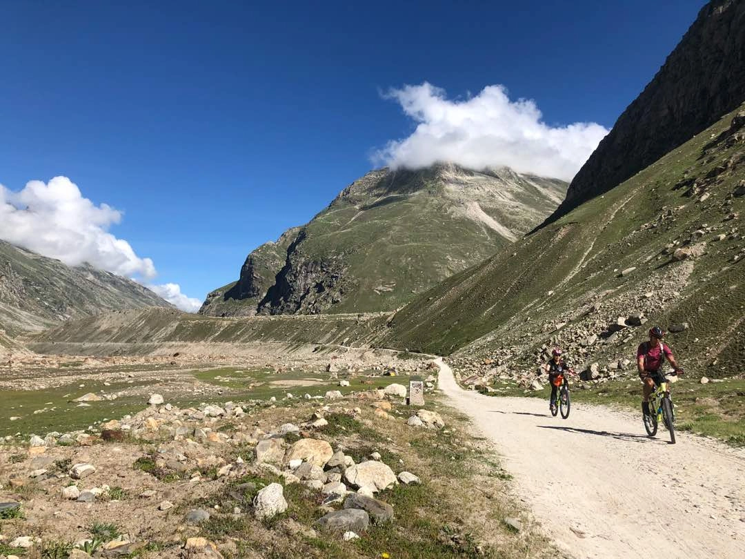 Long-distance touring cyclist passing chatru in Spiti Valley